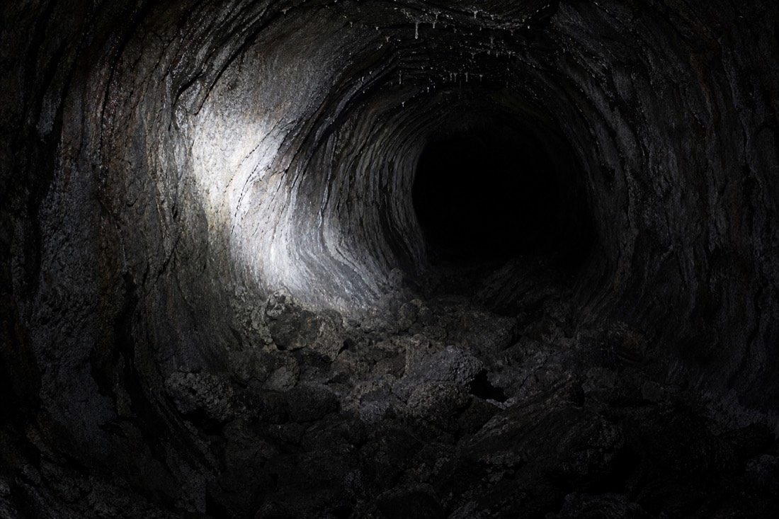Inside the lava tube at Kaumana Caves, where the walls still show the shape of the flowing lava