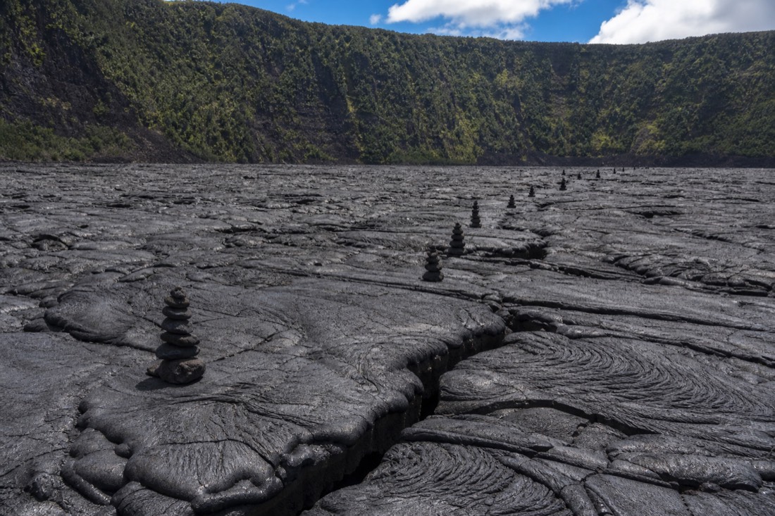 Stacked stone cairns marking the route across the hardened lava lake