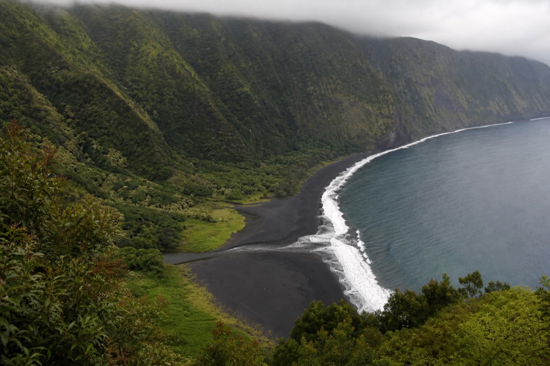 The black sand beach at Waipiʻo Valley's river mouth, visible from the lookout above