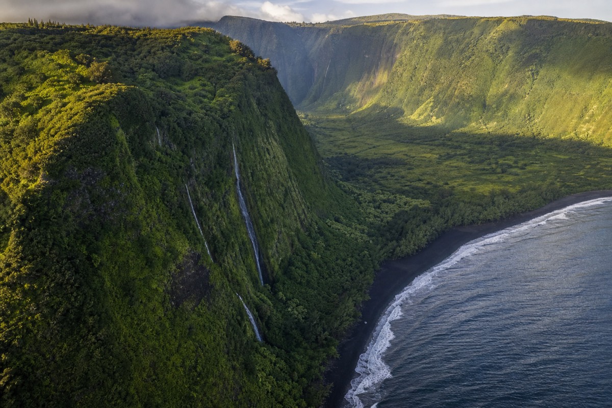 Aerial view of green cliffs and waterfalls above Waipiʻo Valley on Hawaii's Big Island