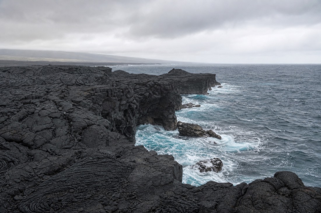 Waves against a black lava rock shoreline on the Big Island